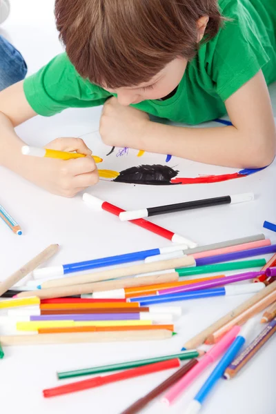 Boy doodling on white paper