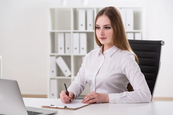 Businessswoman sitting in front of laptop and m