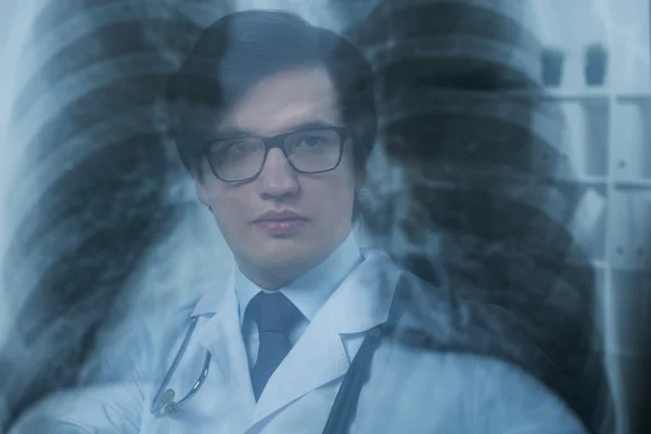 Doctor face behind x-ray