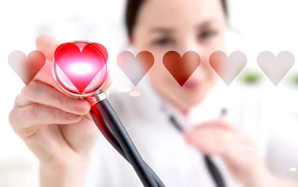 Female doctor listening to abstract heartbeat with stethoscope