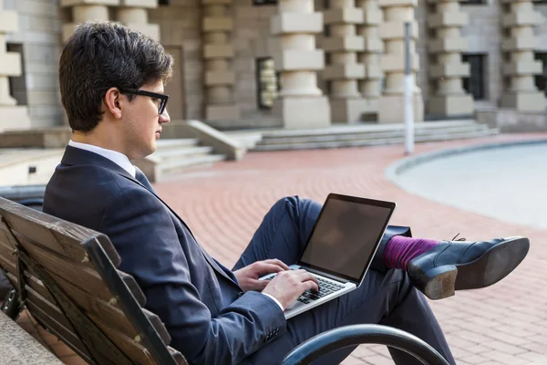 Attractive businessman using laptop side