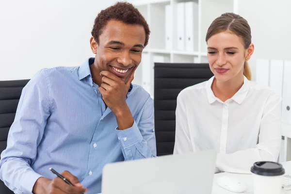 Man and woman working sitting at office table