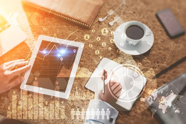 Top view of a man at his workplace in office. Tablet, smart phone and coffee on table. Graphs and schemes on foreground. Concept of office work. Elements of this image furnished by NASA. Toned image. Double exposure
