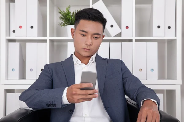 Texting Asian businessman