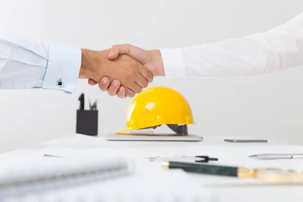 Contractor and company executive sealing a deal shaking hands. Concept of new job opportunities and city development