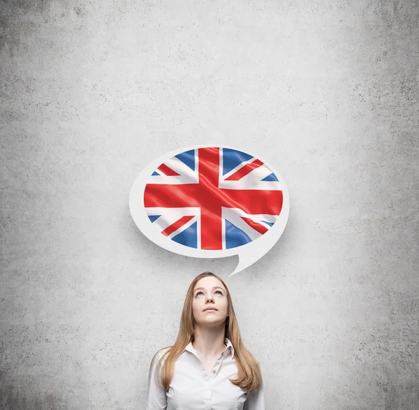 Beautiful woman and the thought bubble above the head with Great Britain flag. Concrete background.