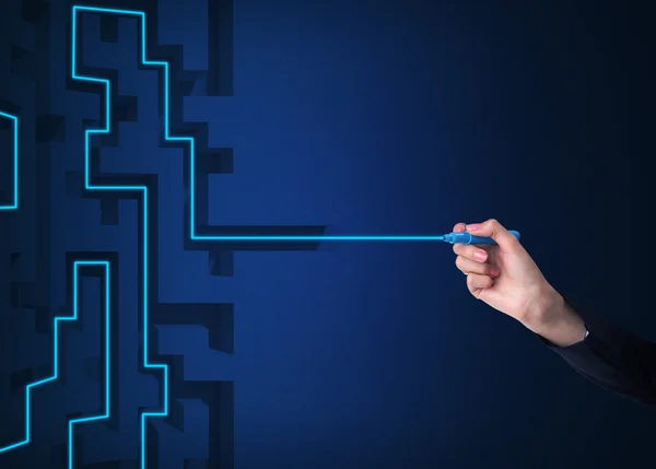A hand is drawing a line as a maze solution. Dark blue background.
