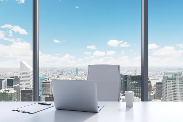A workplace in a modern panoramic office with New York view. A white table, white leather chair. Laptop, writing pad and a cap of coffee are on the table. Office interior. 3D rendering.