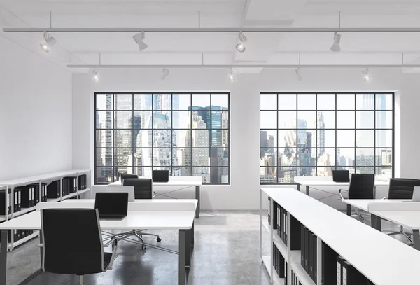 Workplaces in a bright modern loft open space office. Tables equipped with laptops; corporate documents\' shelves. New York in the panoramic windows. 3D rendering.