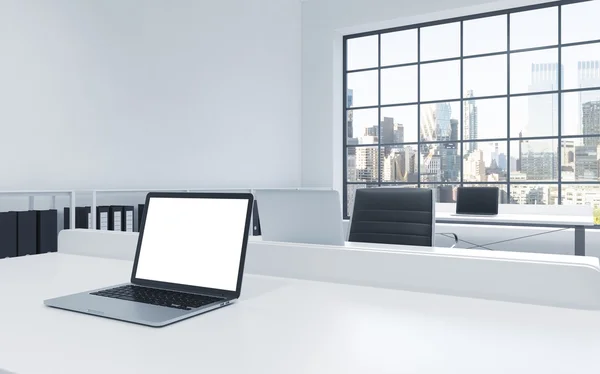 Workplaces in a bright modern loft open space office. Tables equipped with laptops, white copy space in the screen. Docs shelves. New York view in the panoramic windows. 3D rendering.