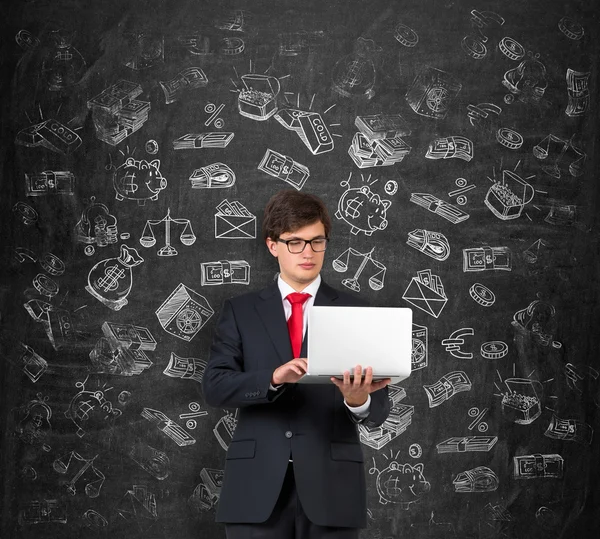 Young man holding a computer and working, white pictures symbolizing money around him.