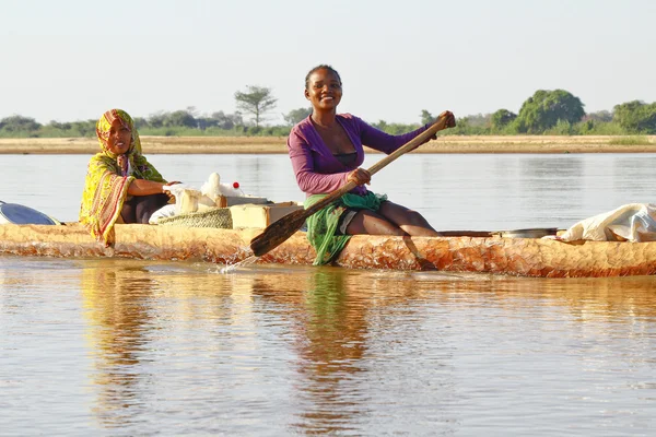 Malagasy people crossing the inlets in an outrigger canoe