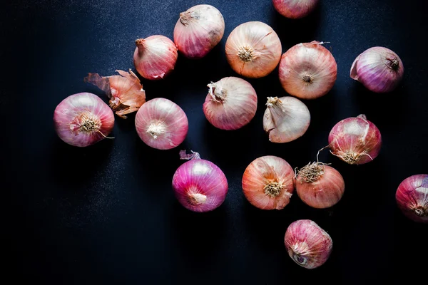 Organic Red Pearl Onions on wooden background