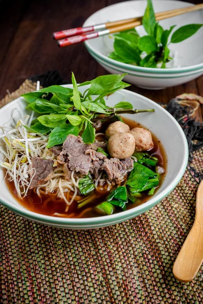 Asian noodle soup with beef meatball with fresh vegetable on woo