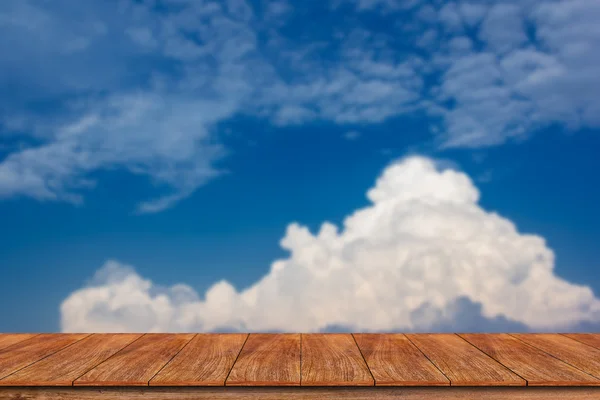 Wood table top on blurred blue sky background