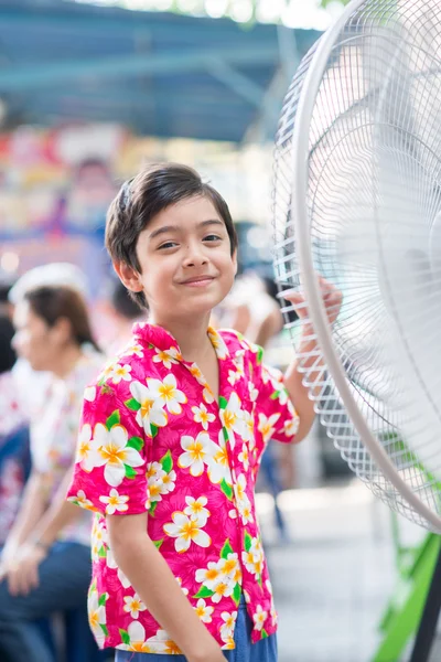 Little boy in front of electric fan in the summer hot time