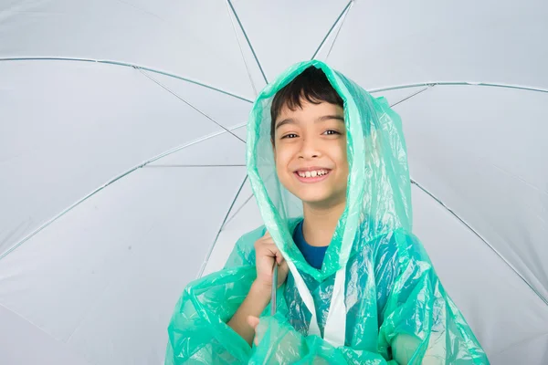 Little boy wearing rain coat on white background