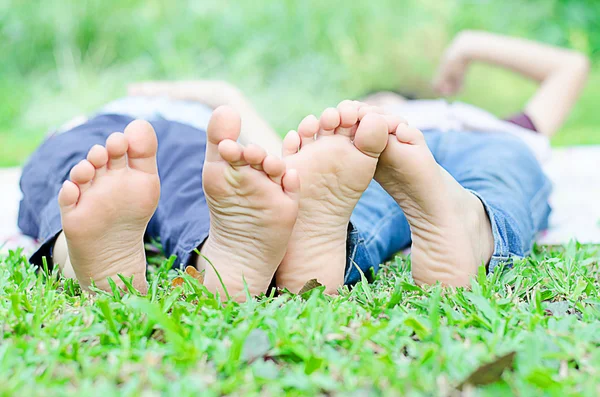 Little boy lay on grass show feet in the park