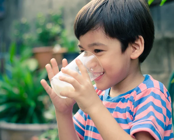 Littl boy drinking milk in the park vintage style