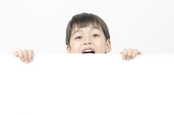 Little boy with surprise face behind the whiteboard