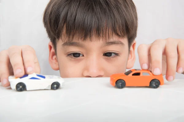 Little boy playing car toy on the table