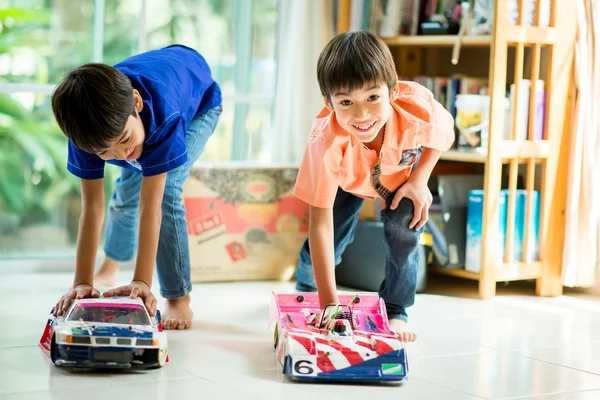 Little sibling boy playing car toy race together indoor