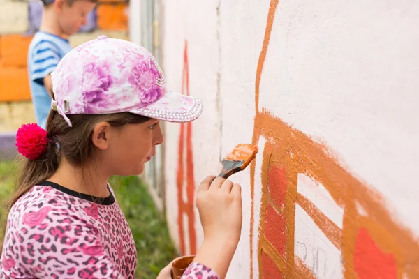 Children draw a picture on the wall