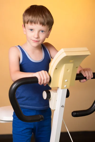 The child is trained on a stationary bike . Healthy lifestyle.