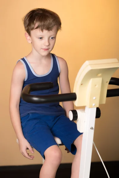 The child is trained on a stationary bike . Healthy lifestyle.