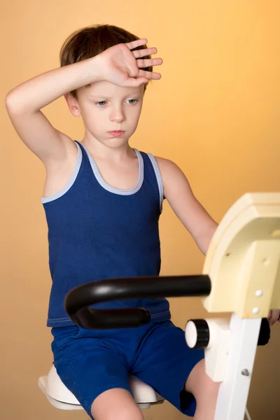 The child is trained on a stationary bike . Healthy lifestyle.