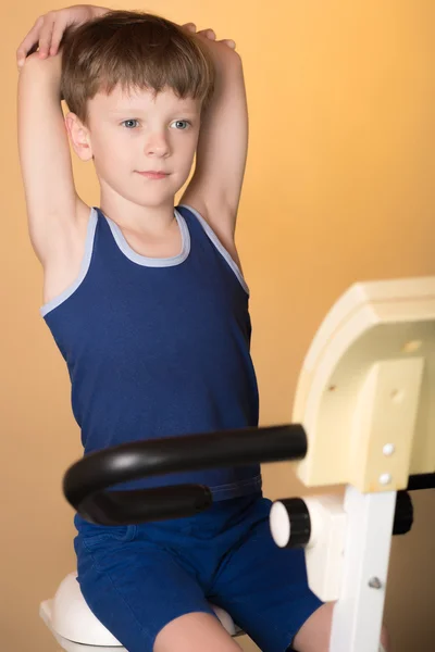 The child is trained on a stationary bike . Healthy lifestyle.