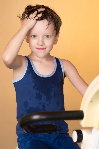 The child is trained on a stationary bike . Healthy lifestyle.