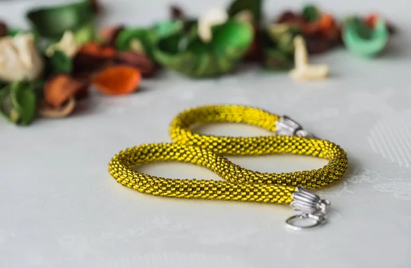 Shining yellow beaded crochet necklace on textile background
