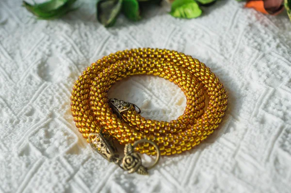 Knitted necklace from transparent yellow beads