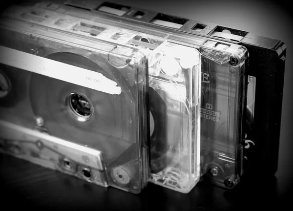 Stack of old audio tapes on a dark wooden background close up