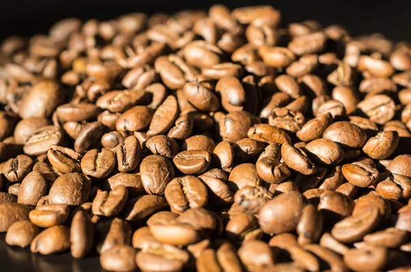 Background of roasted coffee beans lit by the sun