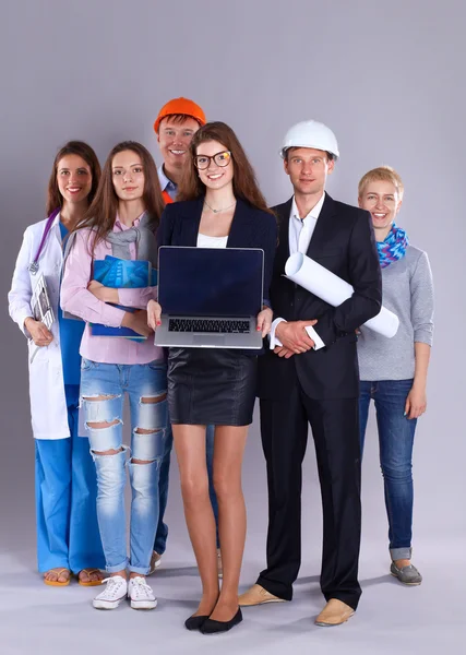 Smiling businesswoman with laptop  and group of industrial workers