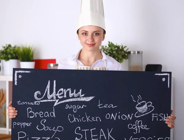 Chef woman holding the menu board , standing in kitchen