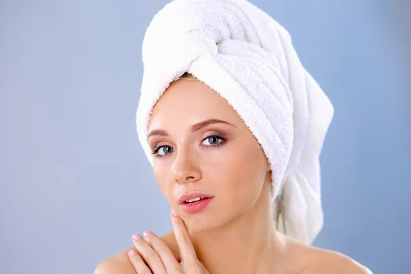 Beautiful woman with a towel on his head on a gray background