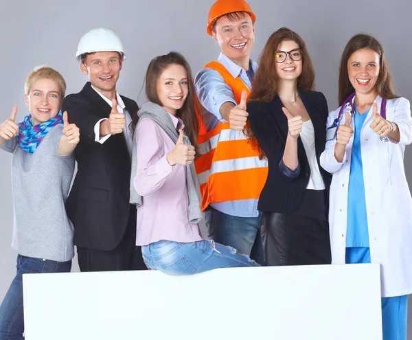 Happy group of people of different professions holding a blank billboard.