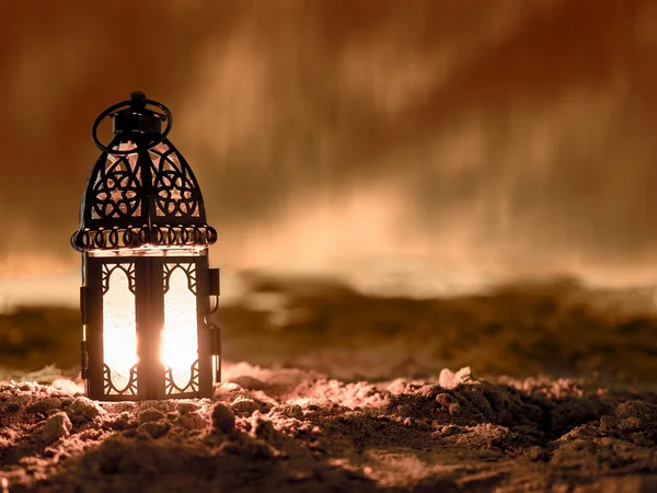 Lighting with candle inside Lantern shining on sand