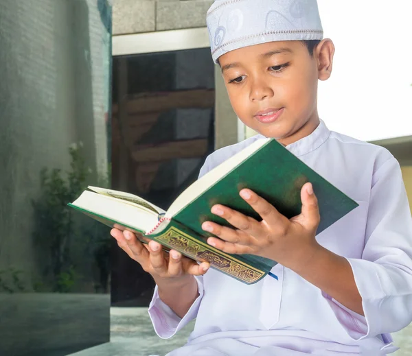 Asian muslim child with smile face reads the holy Quran