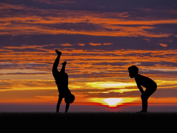Silhouette of two little boys playing sunset sky