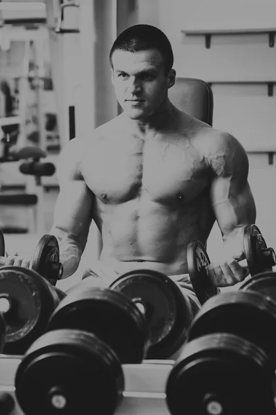 Muscular guy working with free weights.
