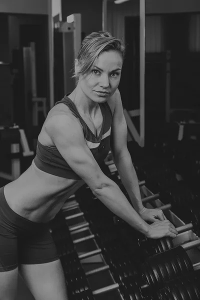 Sport blonde. Beautiful strong girl. Bodyfitness, women\'s fitness. Woman doing exercises at the gym. Beauty, health, and sports.Bodybuilder young adult sexy girl