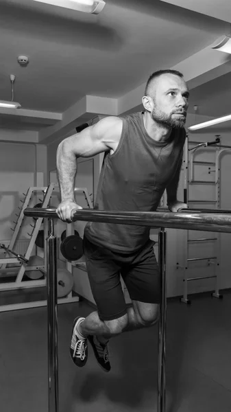 Strength training professional athlete in the gym. Work on tell muscles of the body. Performing difficult exercises to achieve results. Photos for sporting magazines, posters and websites.