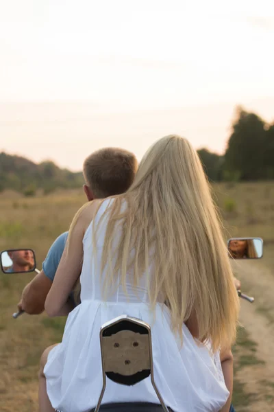 Newlyweds middle of the field on a motorcycle road. Happy couple traveling on a motorcycle.