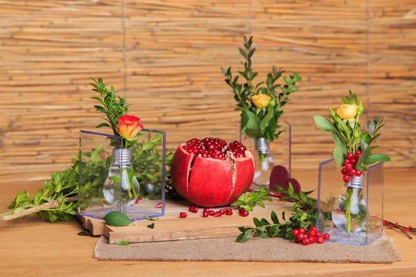 Beautiful composition with pomegranate, flowers and bulbs.