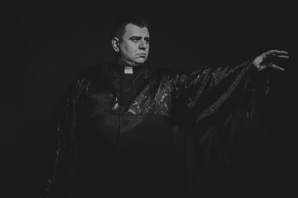 The professional game stage actor at the camera in the image of the priest. Theatrical productions. Professional makeup and costume designer. Photo for religious and cultural magazines and websites.