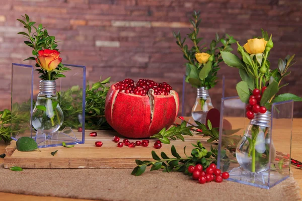 Beautiful composition with pomegranate, flowers and bulbs.